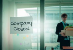 a man standing in front of a glass door with a sign